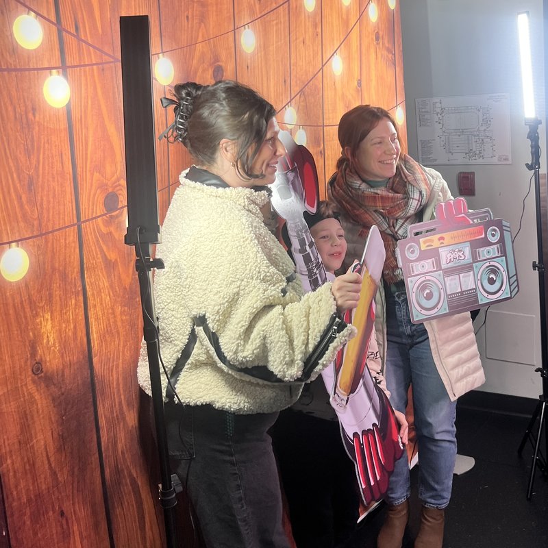 Family having fun with props at wood backdrop